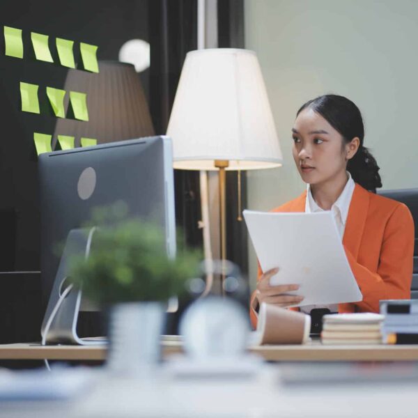 Young adorable Asian businesswoman working with work document during the night, working overtime at night.