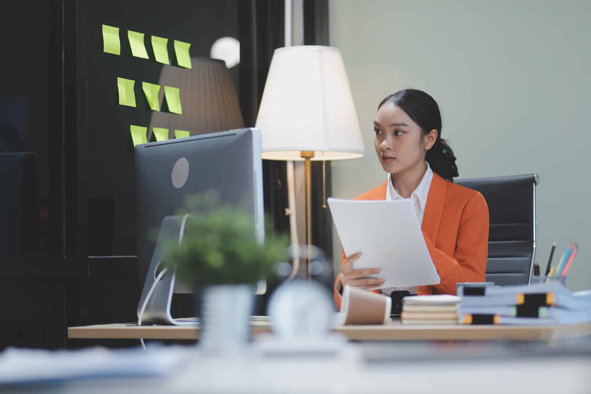 Young adorable Asian businesswoman working with work document during the night, working overtime at night.