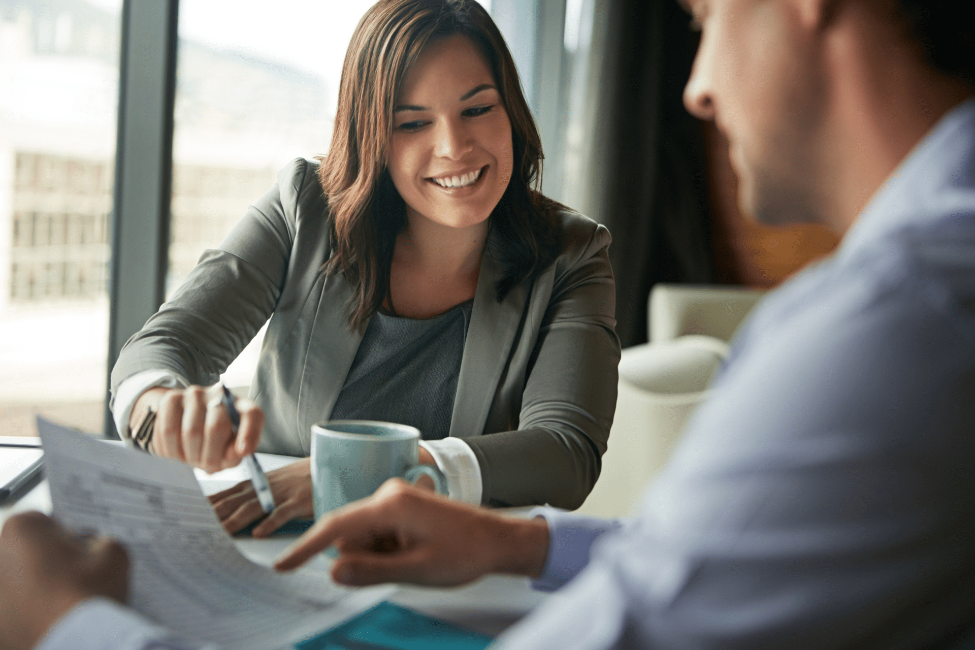 woman pointing to something on her desk while talked to a male client