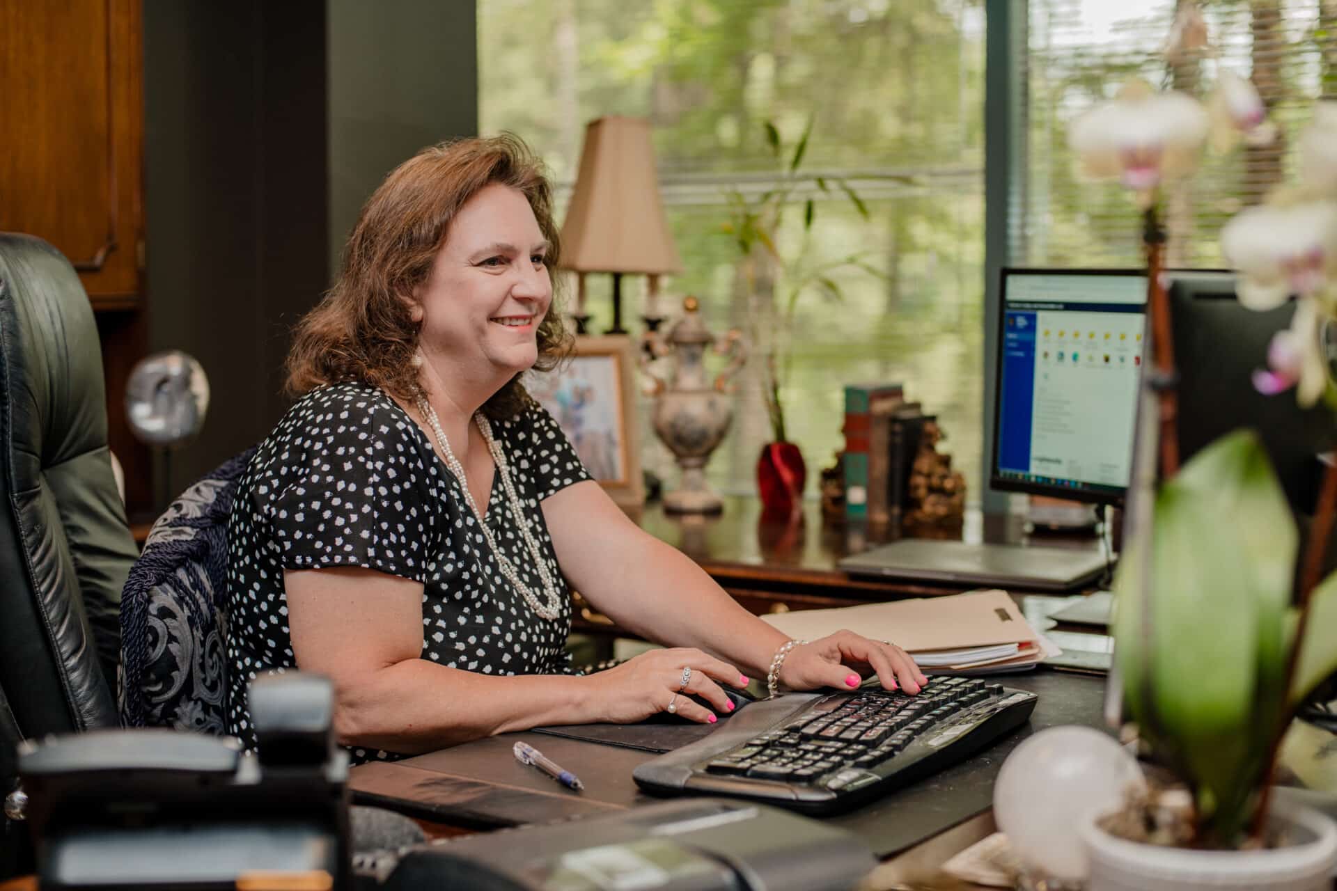 older woman sitting at her desk working