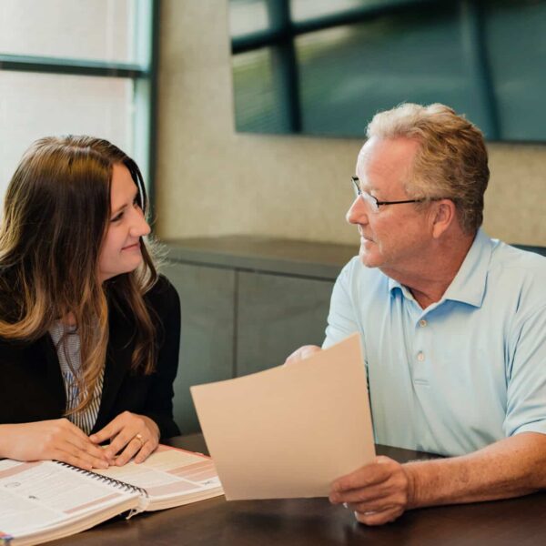 representative goes over some data with a client in a small conference room