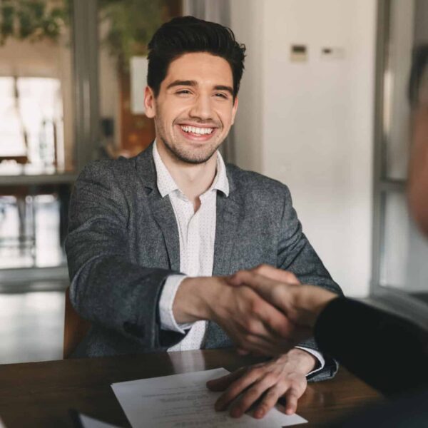 Business, career and placement concept - happy caucasian man 30s rejoicing and shaking hands with employee when was recruited during interview in office