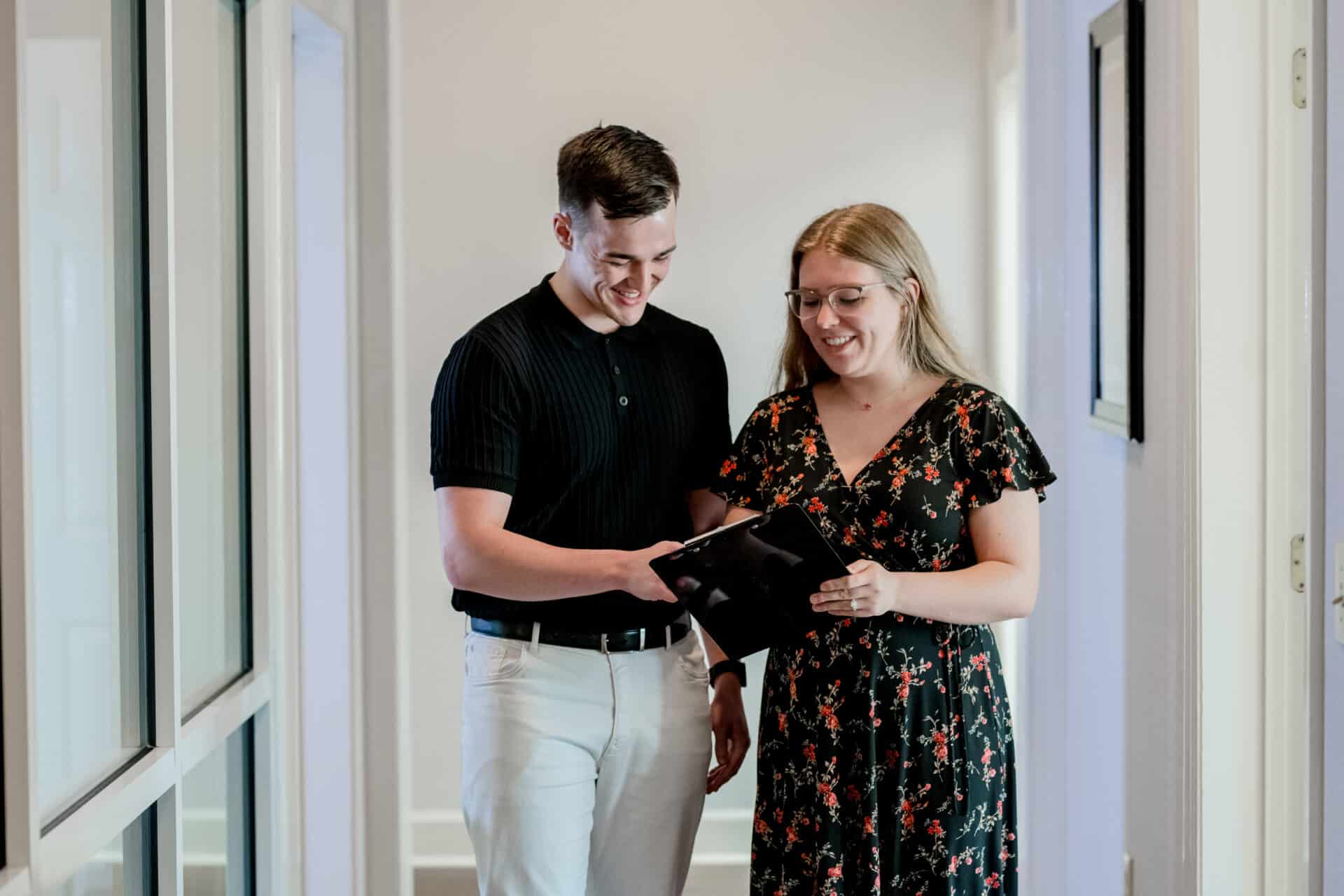 representative showing client information on a tablet while both are standing up
